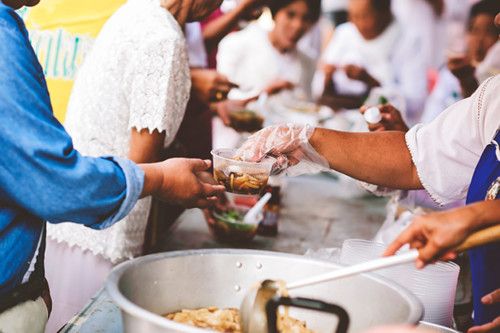 Volunteers serving food to relieve hunger.