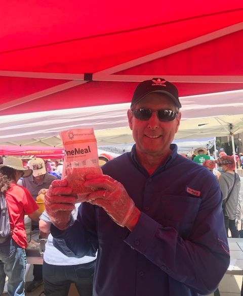 A volunteer at a Million Meal Event holding up a packaged meal.